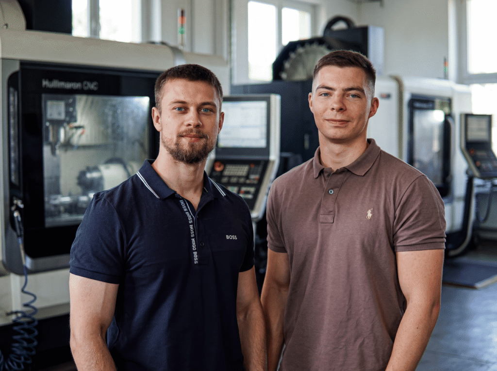 Zwei Ansprechpartner stehen gemeinsam in einer Produktionshalle