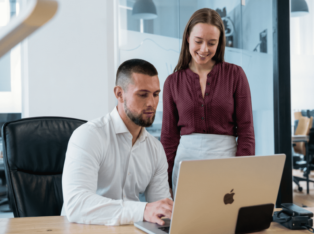 Zwei Mitarbeitende besprechen gemeinsam eine Kampagne am Laptop