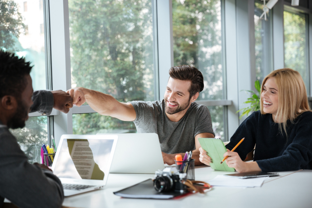 Team bespricht sich gemeinsam an einem Arbeitstisch